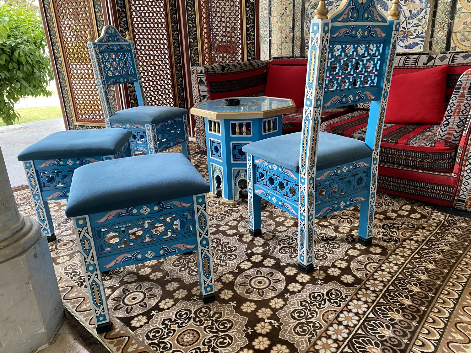 Chaises et poufs bleus peints à la main autour d'une table